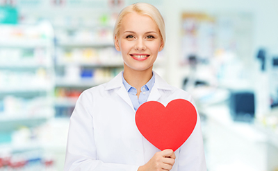 Smiling pharmacist holding a heart shape